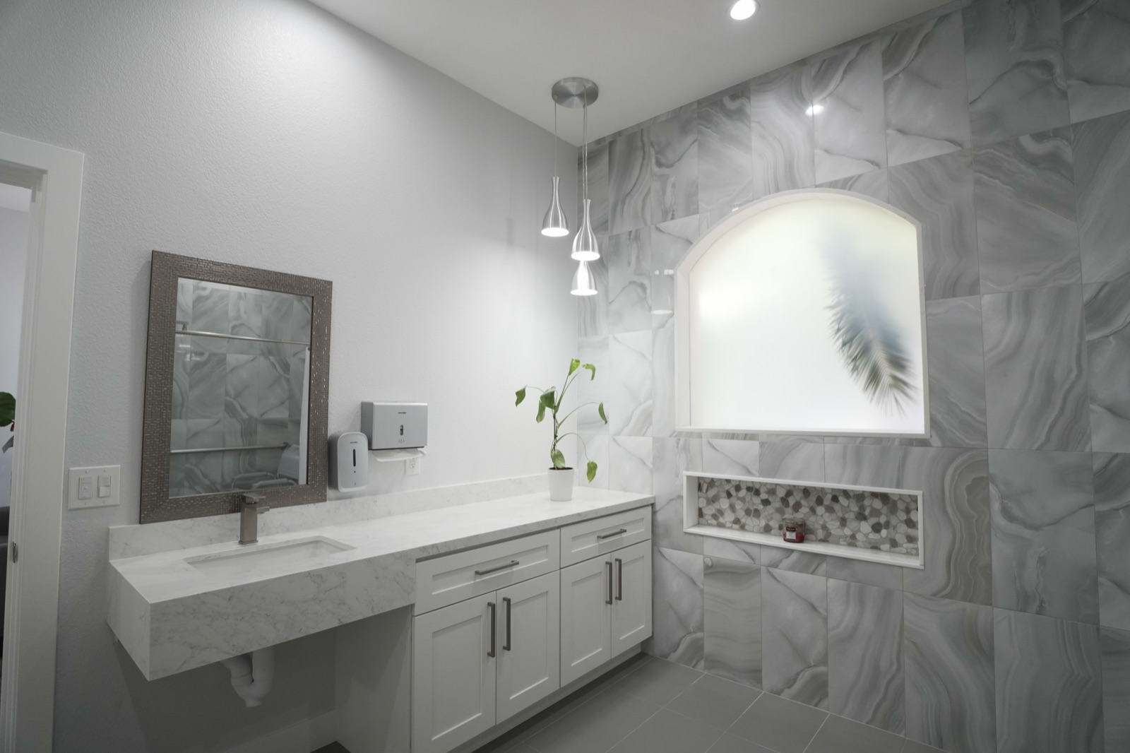 A bright bathroom with a wide vanity and large mirror